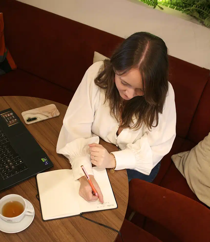 Une graphiste à Pacé écrit dans son carnet sa stratégie de communication